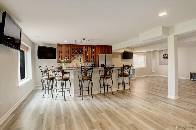 23427 Song Bird Hills Pl, Parker, CO 80138 - kitchen featuring stainless steel refrigerator with ice dispenser, a kitchen bar, a peninsula, light wood-style floors, and recessed lighting