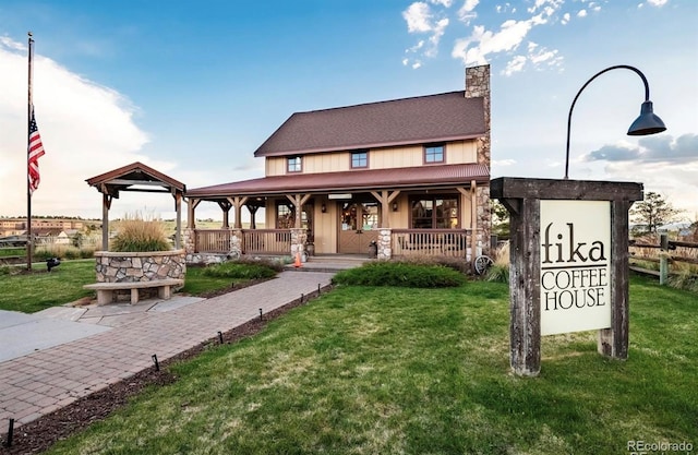 23427 Song Bird Hills Pl, Parker, CO 80138 - view of front of home with a porch, a chimney, and stone siding