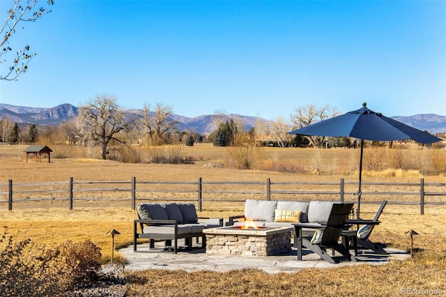 view of yard featuring a rural view, a mountain view, a fire pit, and fence