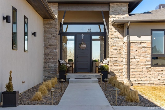 view of exterior entry featuring stone siding and stucco siding