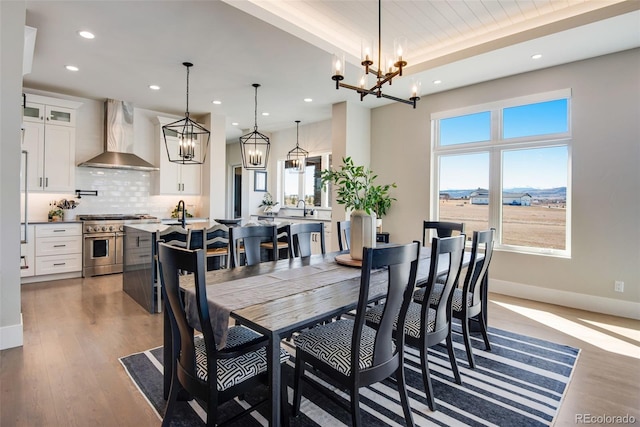 dining space with recessed lighting, a chandelier, baseboards, and wood finished floors