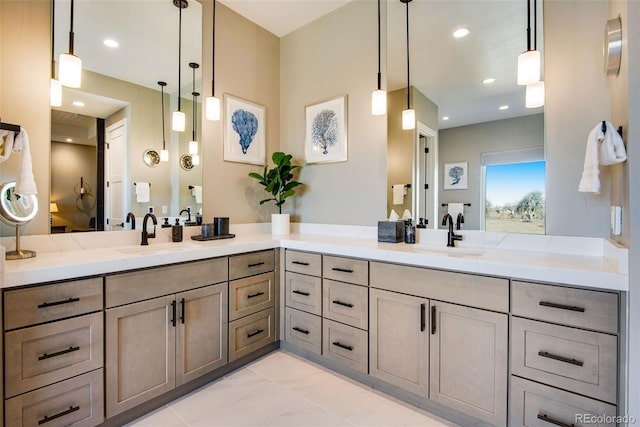 bathroom with a sink, recessed lighting, and double vanity