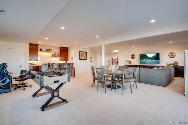 dining room with recessed lighting, light carpet, a bar, and stairs