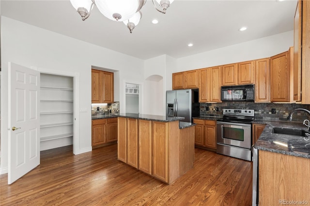 kitchen featuring stainless steel appliances, dark hardwood / wood-style floors, sink, and a center island