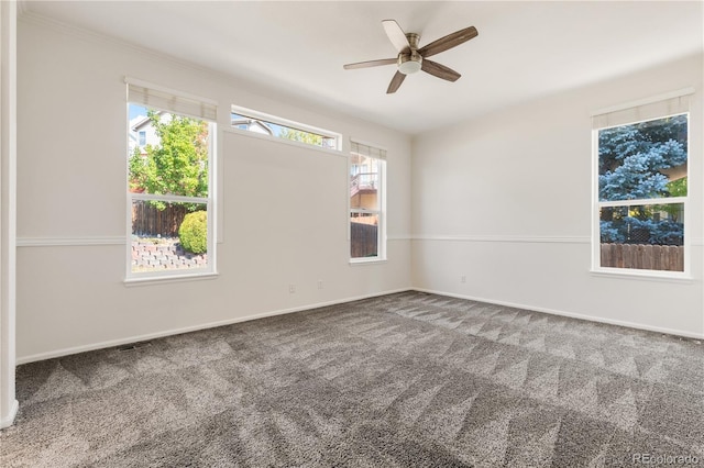 carpeted spare room featuring ceiling fan