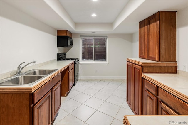 kitchen featuring light tile patterned flooring, a raised ceiling, sink, kitchen peninsula, and black appliances