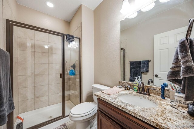 bathroom with toilet, vanity, and an enclosed shower