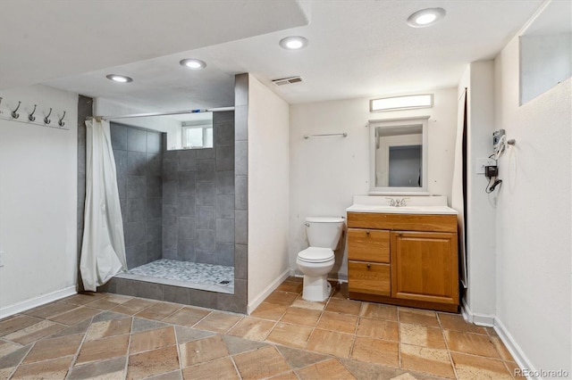 2196 W 56th Ave, Denver, CO 80221 - bathroom with baseboards, stone tile flooring, vanity, toilet, and recessed lighting