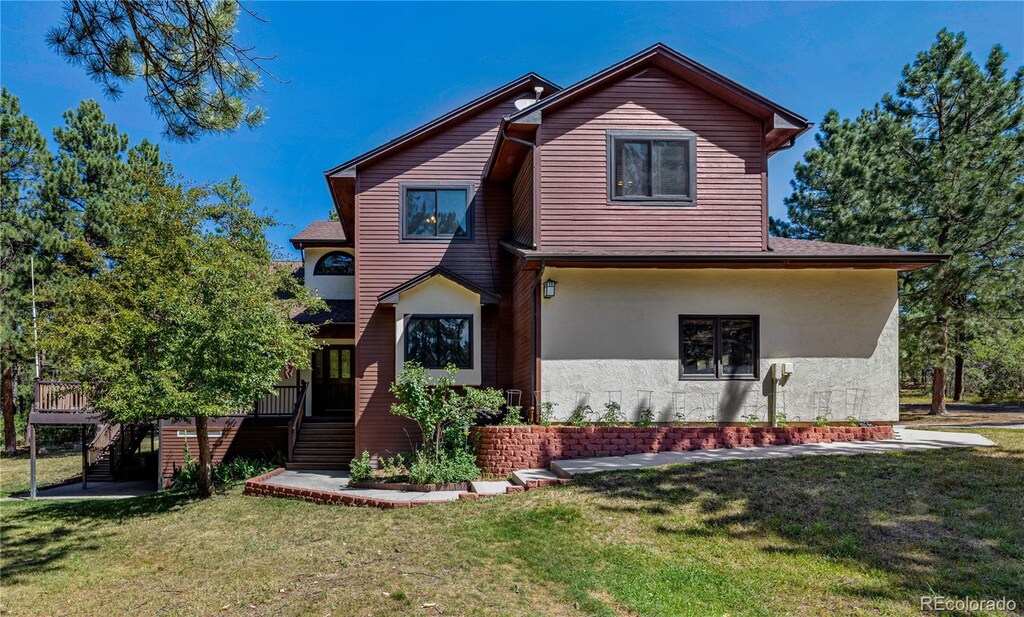 view of property featuring a front yard and a deck