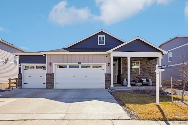 view of front facade featuring covered porch, a shingled roof, concrete driveway, a garage, and board and batten siding