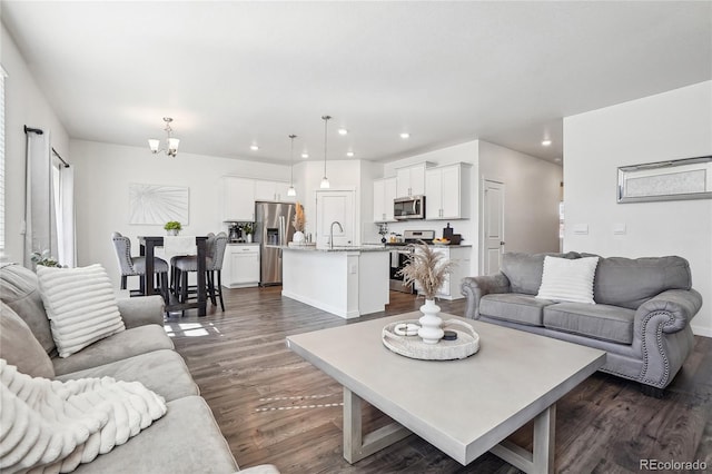 living area with a notable chandelier, recessed lighting, and dark wood-style flooring