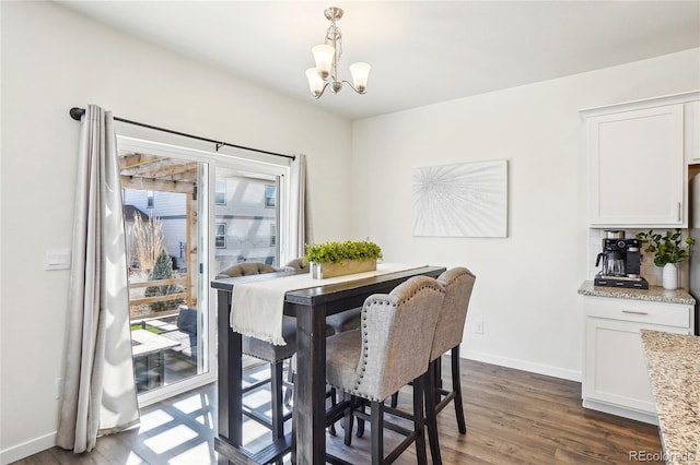 dining space featuring dark wood finished floors, an inviting chandelier, plenty of natural light, and baseboards