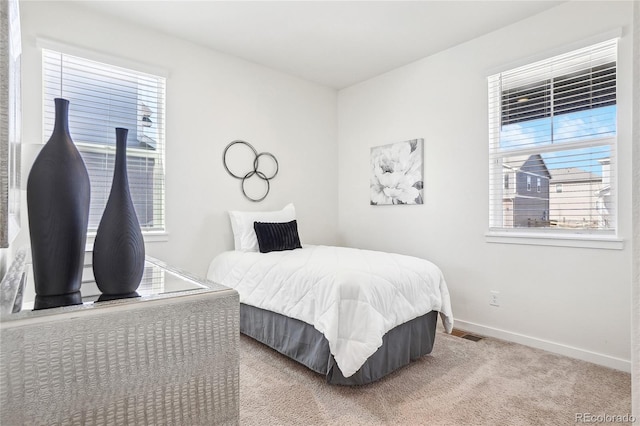 carpeted bedroom with visible vents and baseboards