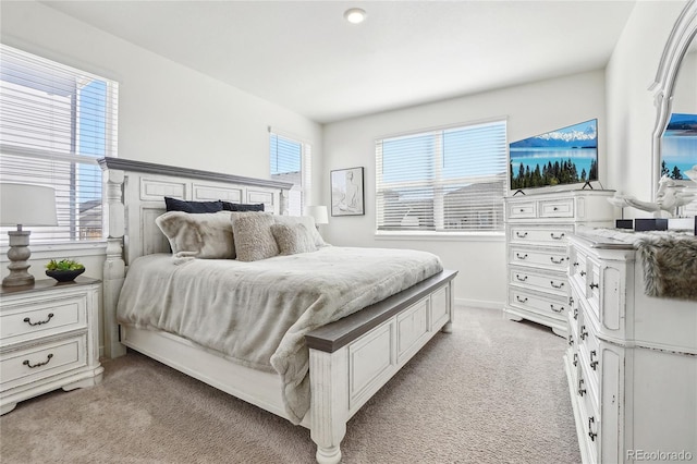 bedroom with light carpet and baseboards