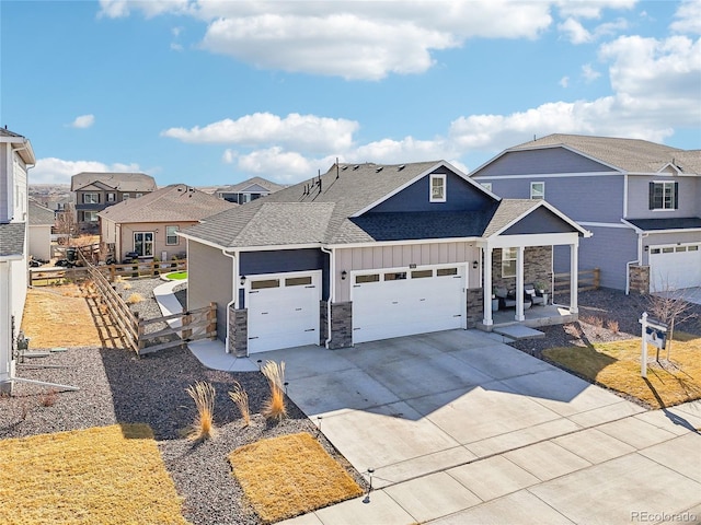 view of front facade featuring driveway, fence, a residential view, board and batten siding, and a garage