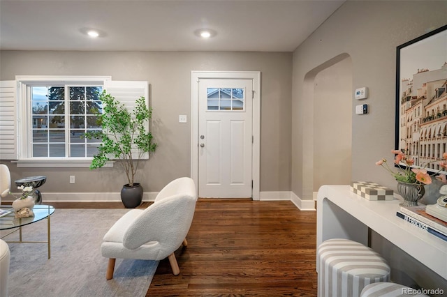 foyer featuring recessed lighting, baseboards, arched walkways, and wood finished floors