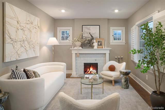 sitting room featuring a brick fireplace, recessed lighting, wood finished floors, and baseboards