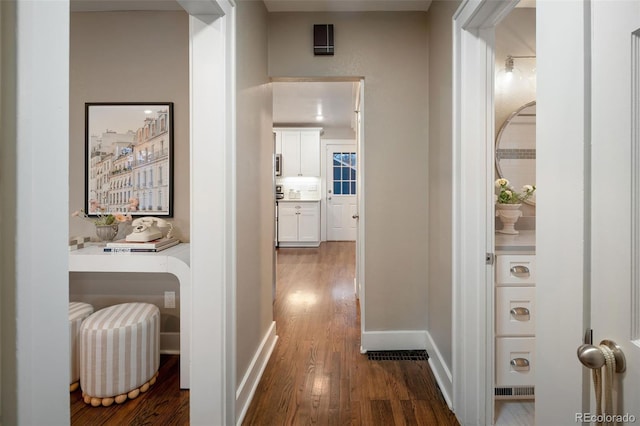 hallway with baseboards and wood finished floors