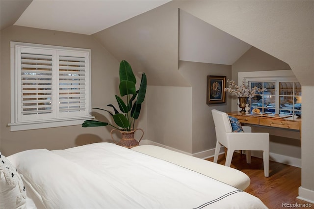 bedroom featuring lofted ceiling, wood finished floors, and baseboards