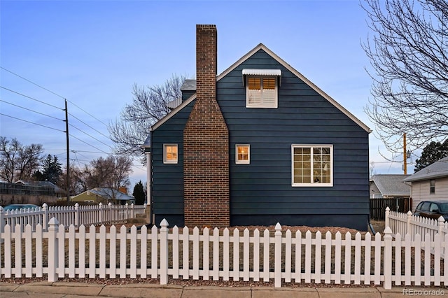 exterior space with a fenced front yard and a chimney