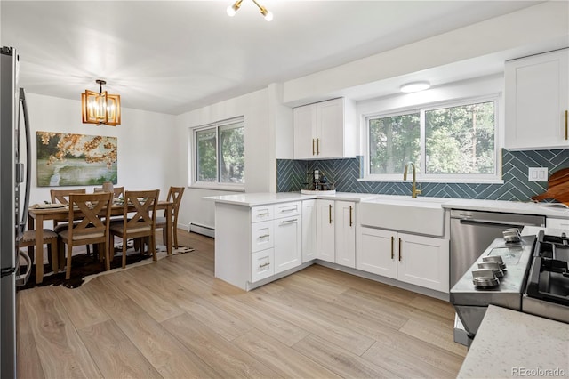 kitchen featuring white cabinets, decorative light fixtures, decorative backsplash, and sink