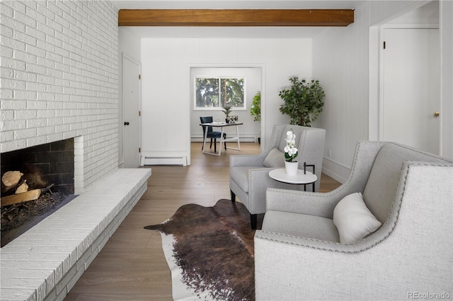 living room with beamed ceiling, hardwood / wood-style floors, a baseboard radiator, and a fireplace