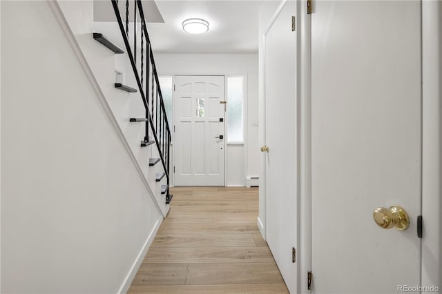 corridor with a baseboard radiator and light wood-type flooring