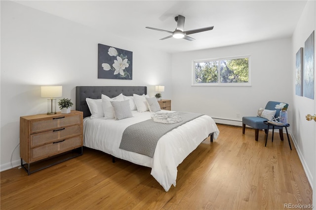 bedroom featuring ceiling fan, hardwood / wood-style floors, and a baseboard heating unit