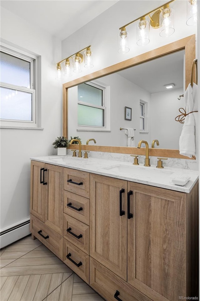 bathroom featuring a baseboard heating unit, vanity, and parquet floors