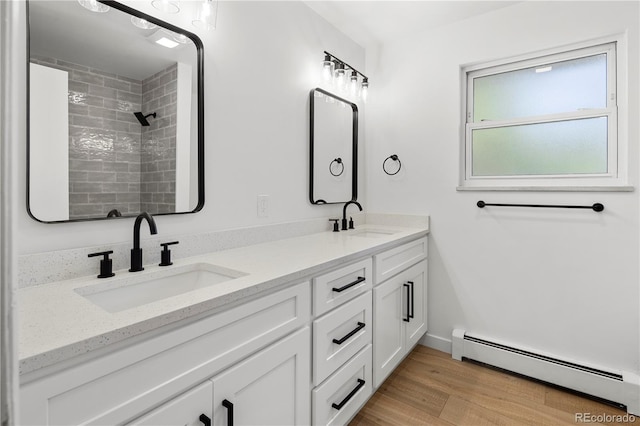 bathroom with baseboard heating, wood-type flooring, and vanity