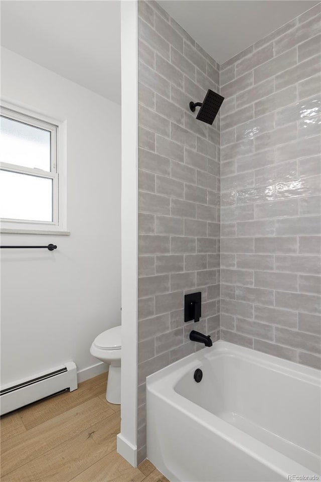 bathroom with baseboard heating, hardwood / wood-style floors, toilet, and bathtub / shower combination