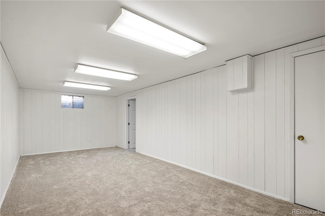 basement with light colored carpet and wood walls