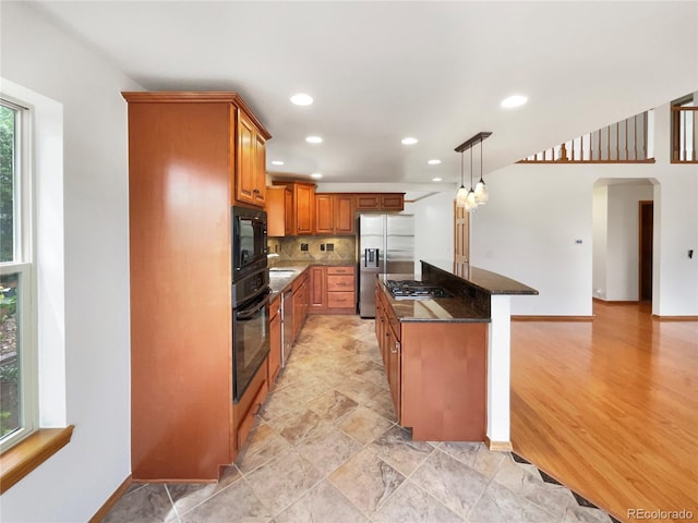 584 W Prestwick Way, Castle Rock, CO 80104 - kitchen with black appliances, arched walkways, brown cabinets, recessed lighting, and backsplash