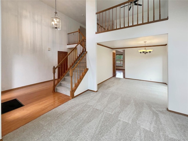 584 W Prestwick Way, Castle Rock, CO 80104 - unfurnished living room featuring a chandelier, stairway, high vaulted ceiling, carpet floors, and baseboards