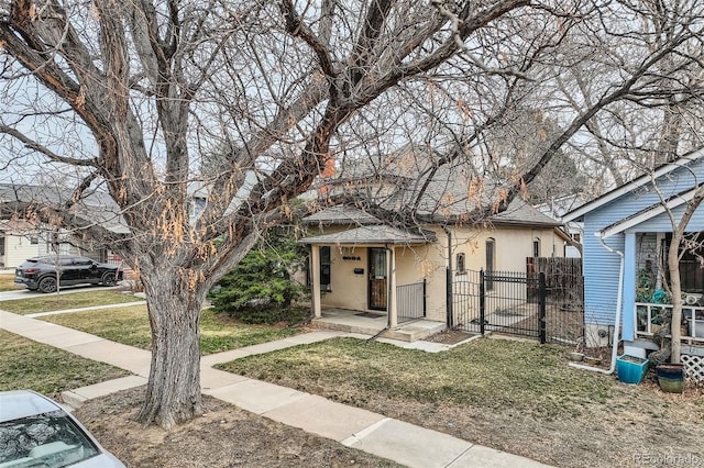 view of front of house featuring fence, a shingled roof, a front lawn, brick siding, and a gate
