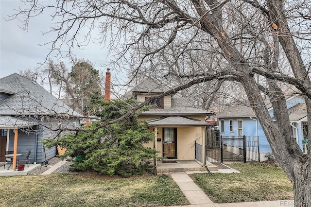 view of front facade with a gate, a front lawn, fence, and a chimney