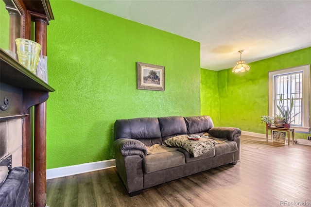 living room with baseboards, a textured wall, and wood finished floors