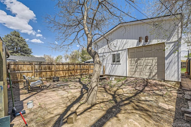 view of yard featuring an outdoor structure, a garage, and fence