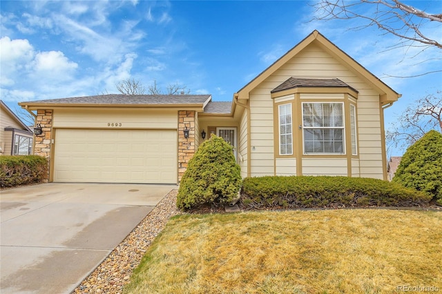 view of front of home featuring stone siding, concrete driveway, a front lawn, and an attached garage