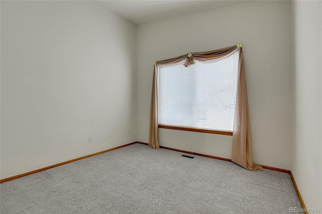 unfurnished room featuring carpet flooring, visible vents, and baseboards