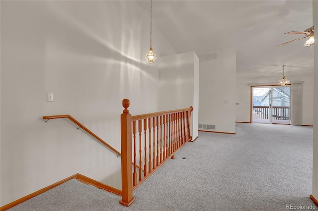 stairs with ceiling fan with notable chandelier, carpet, visible vents, and baseboards