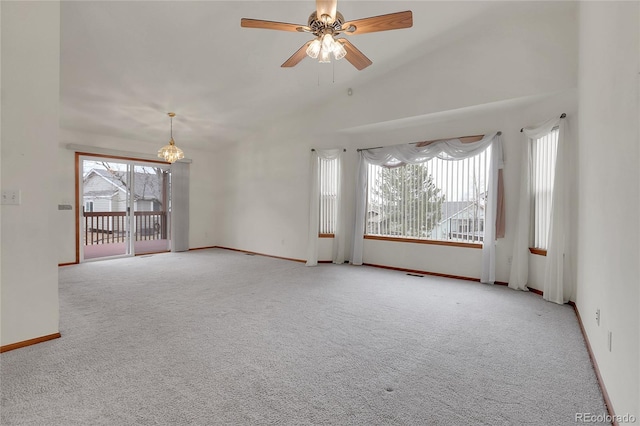 carpeted spare room with visible vents, ceiling fan with notable chandelier, a wealth of natural light, and baseboards