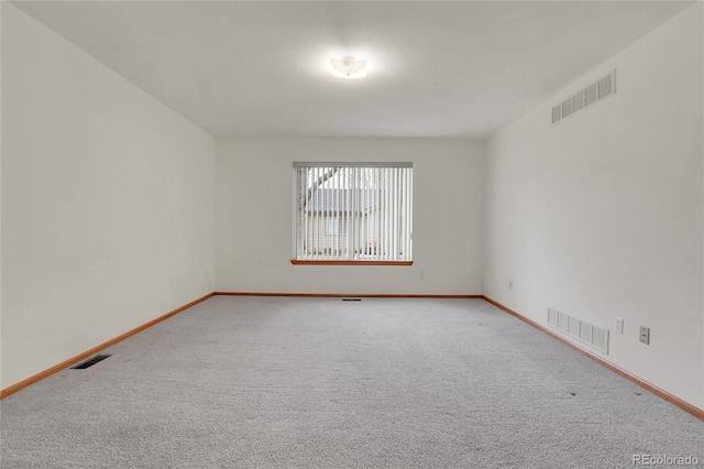 carpeted spare room with baseboards and visible vents