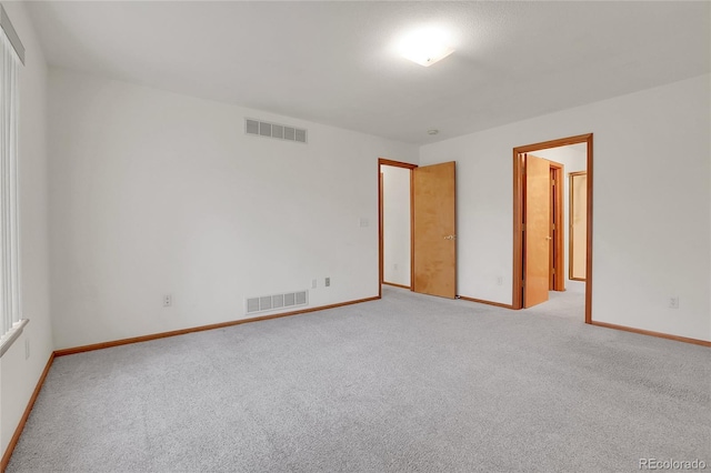 unfurnished bedroom featuring light colored carpet, visible vents, and baseboards