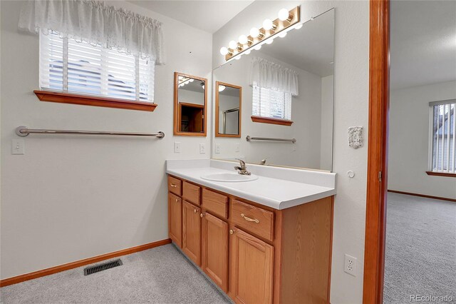 bathroom with vanity, visible vents, and baseboards