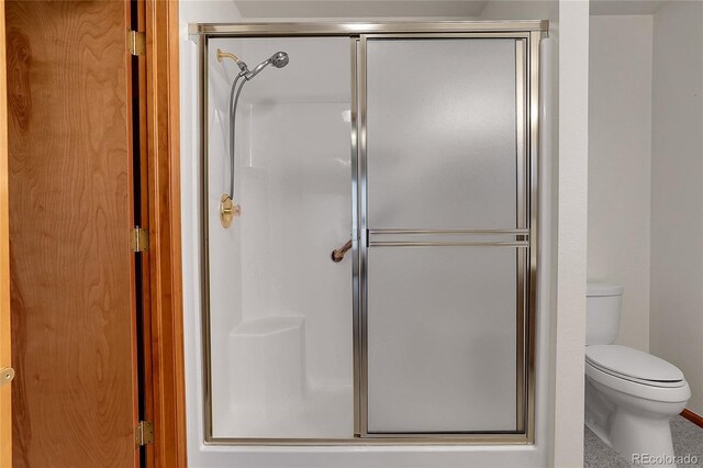 bathroom featuring a stall shower and toilet