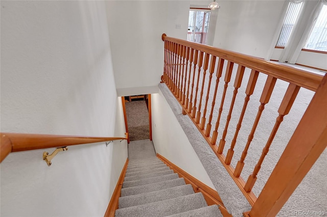 staircase featuring carpet floors and baseboards