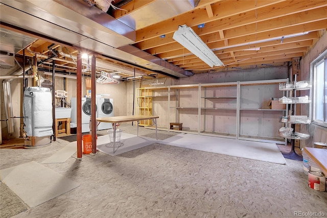 basement with gas water heater, independent washer and dryer, and a sink