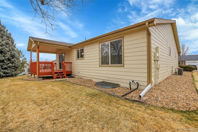 rear view of house with cooling unit, a yard, and a deck