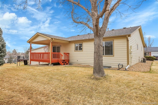 rear view of house with roof with shingles, a lawn, a wooden deck, and central air condition unit